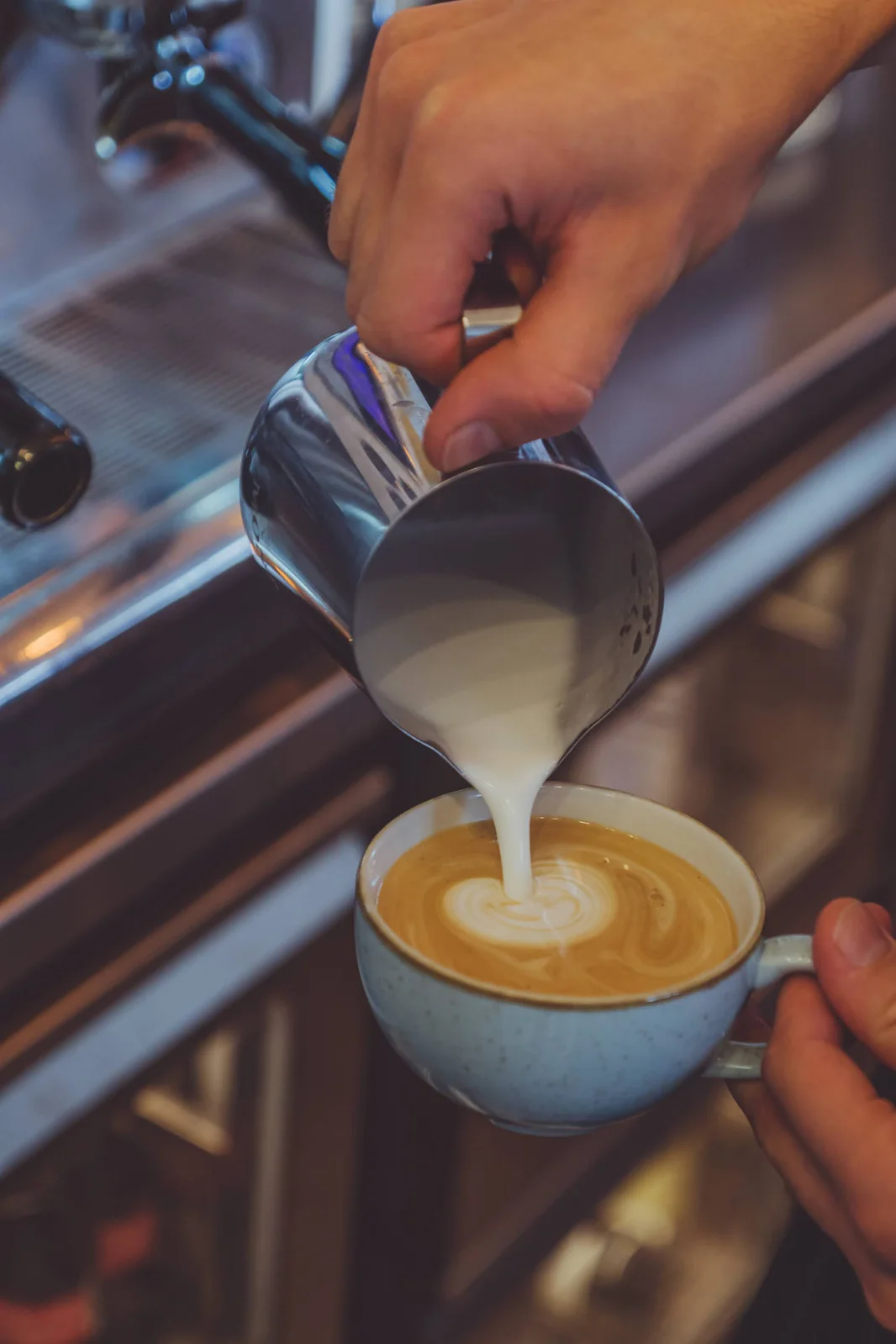 Nalewanie mleka i wzór latte art w filiżance